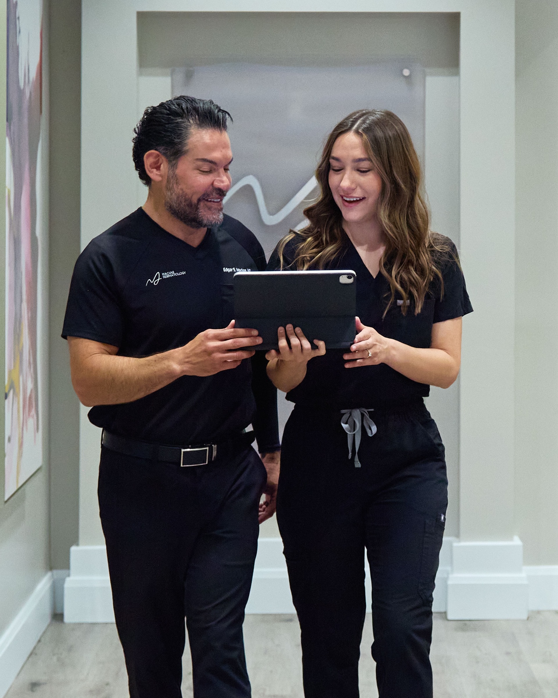 Dr. Macias and a team member reviewing a tablet together in the clinic hallway