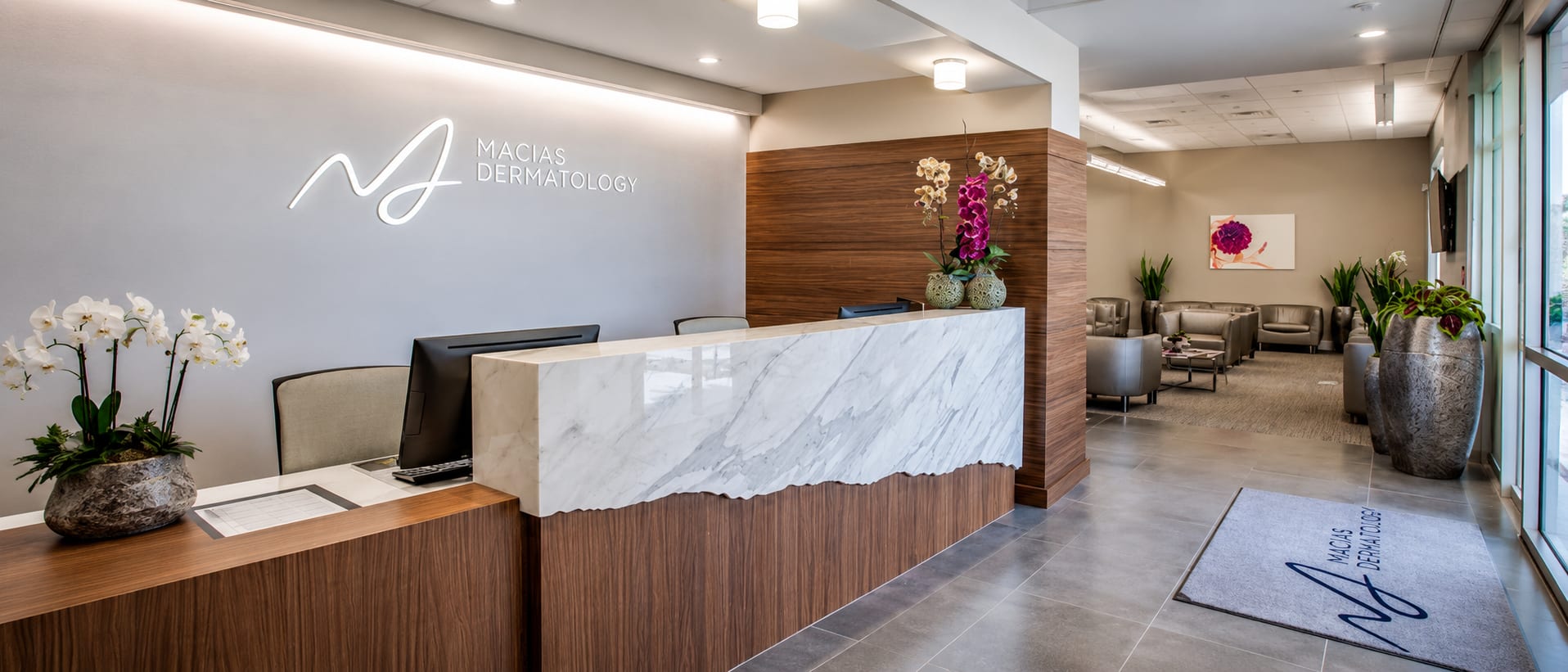 The check-in desk and waiting area beneath the illuminated wordmark