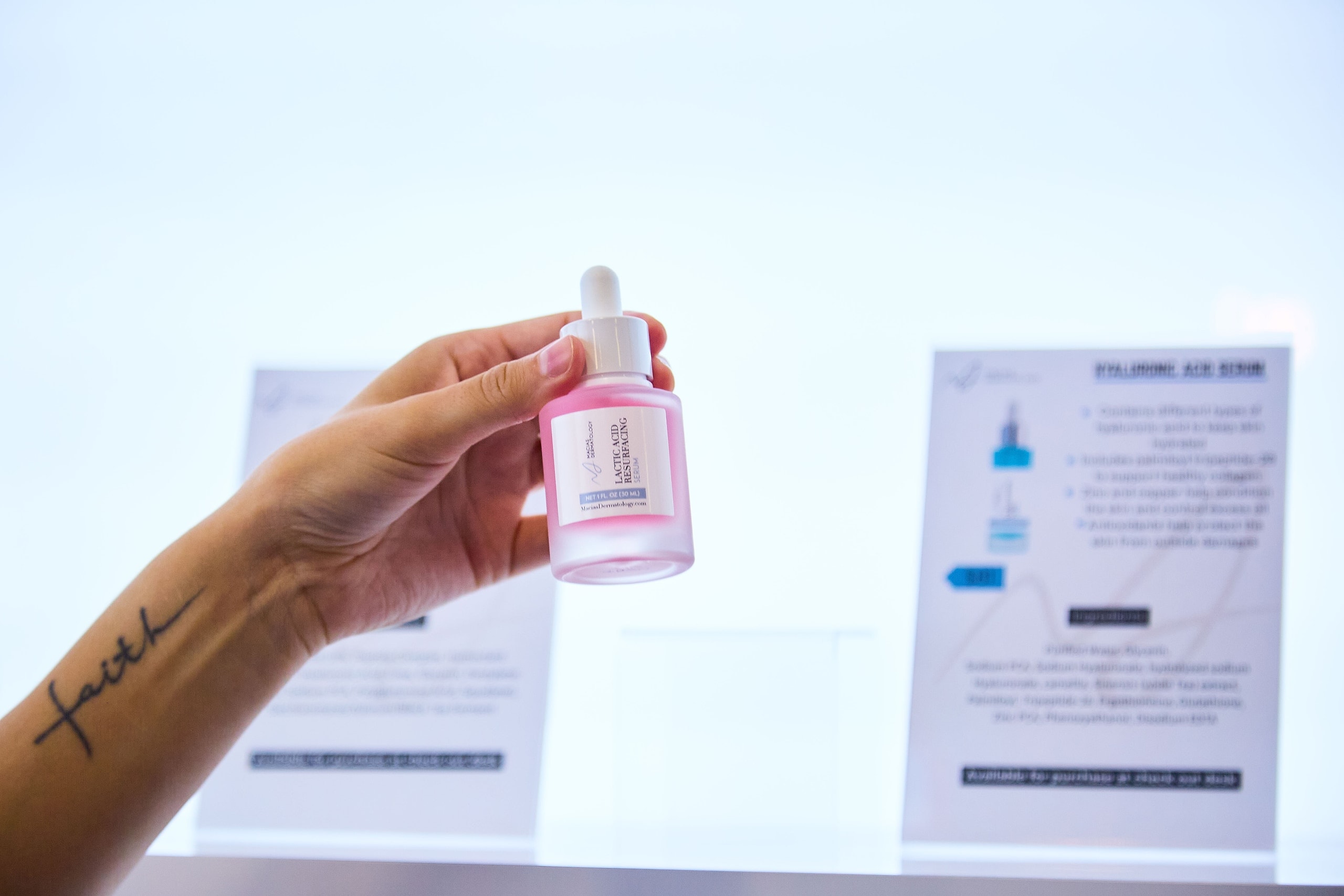 A serum from the practice's skincare line, held at the product wall