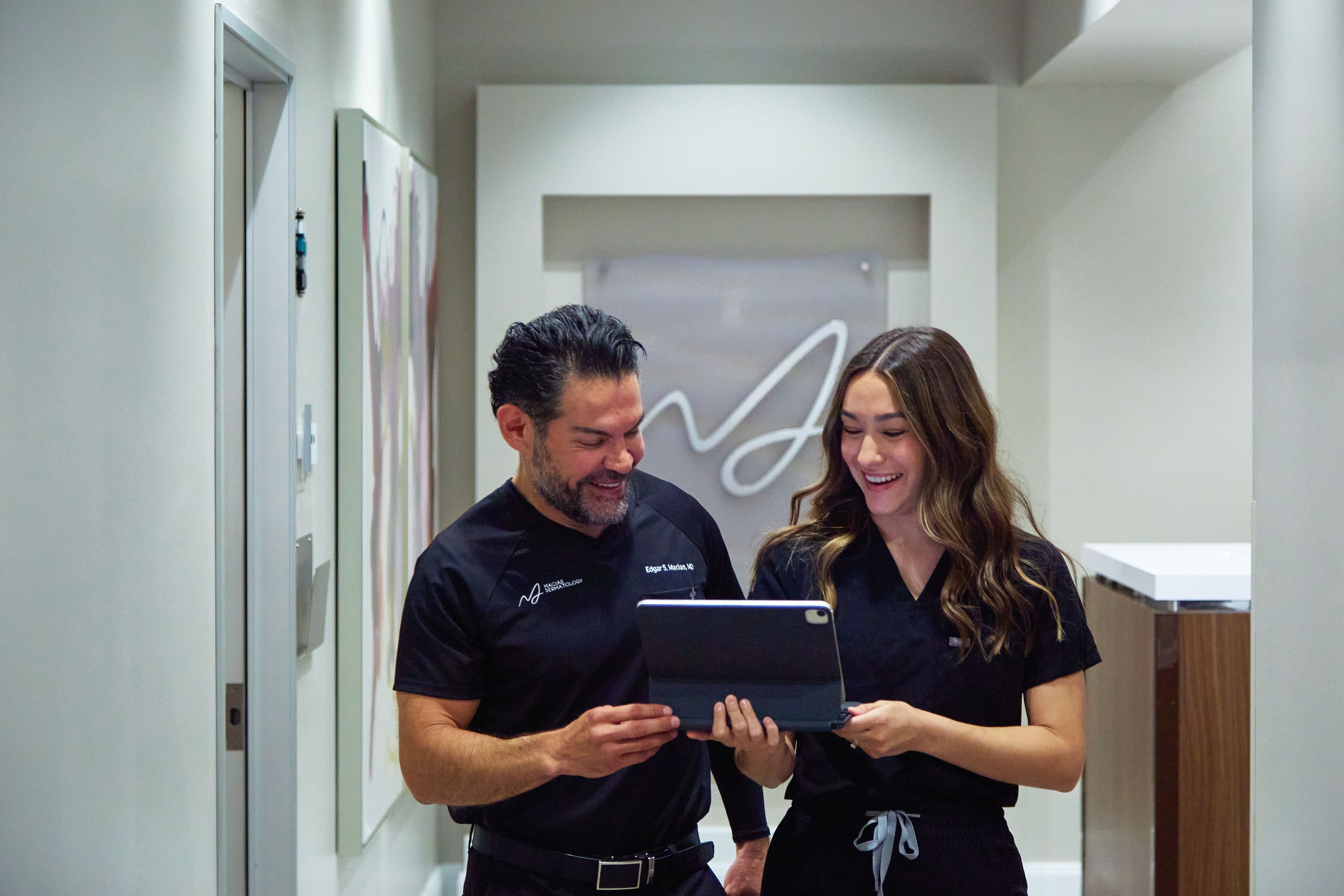 Dr. Macias and a physician assistant reviewing a chart beneath the practice wordmark