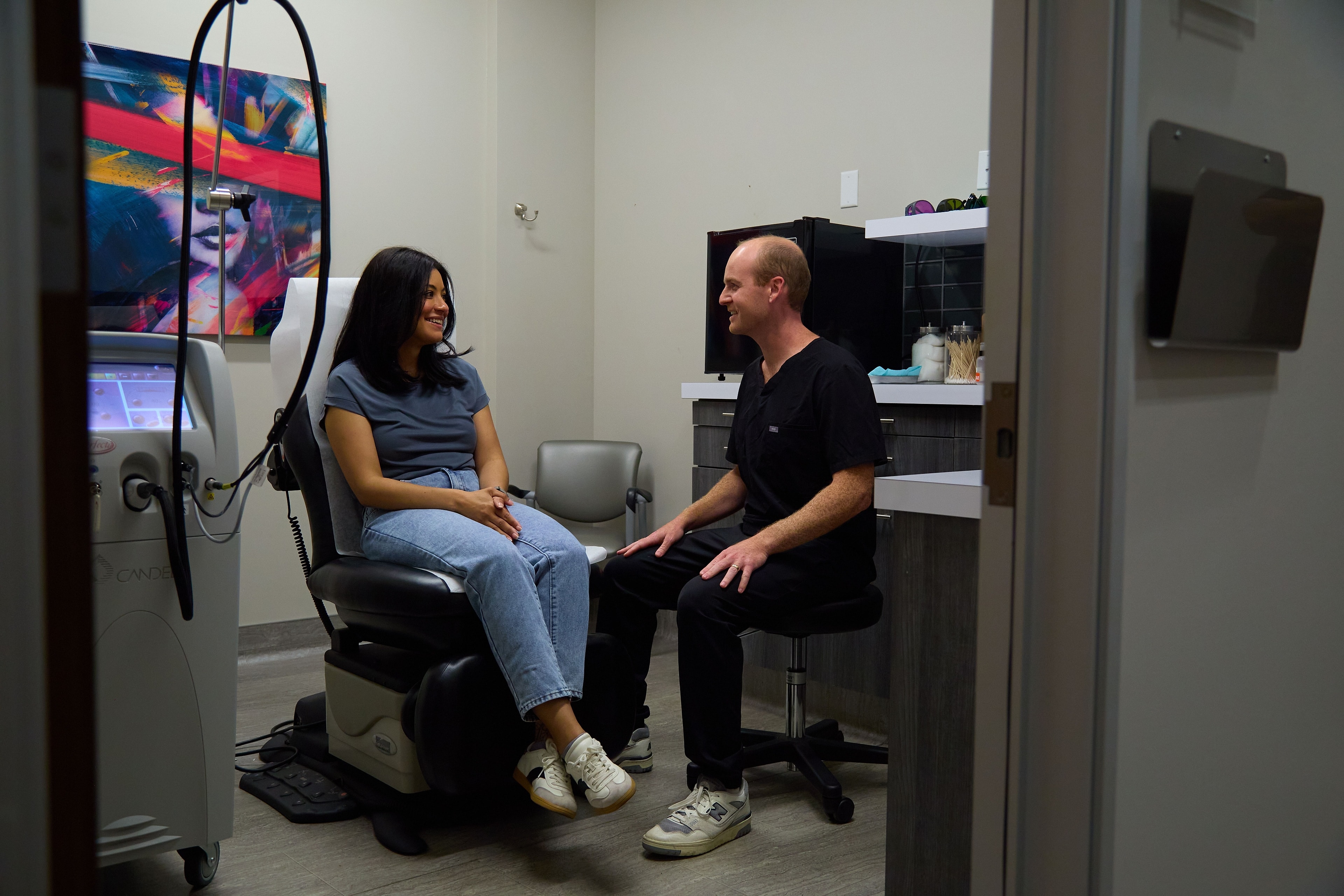 A Macias Dermatology clinician in unhurried conversation with a patient in the exam room