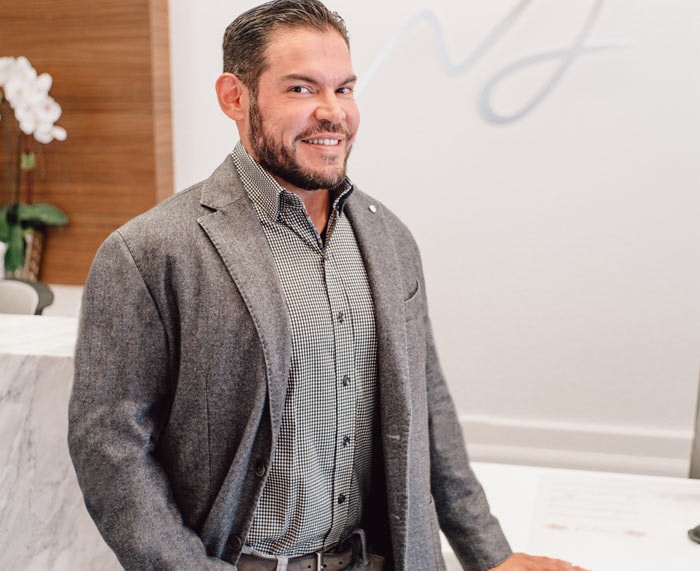 Dr. Edgar Macias at the Macias Dermatology front desk, photographed for Patrick James