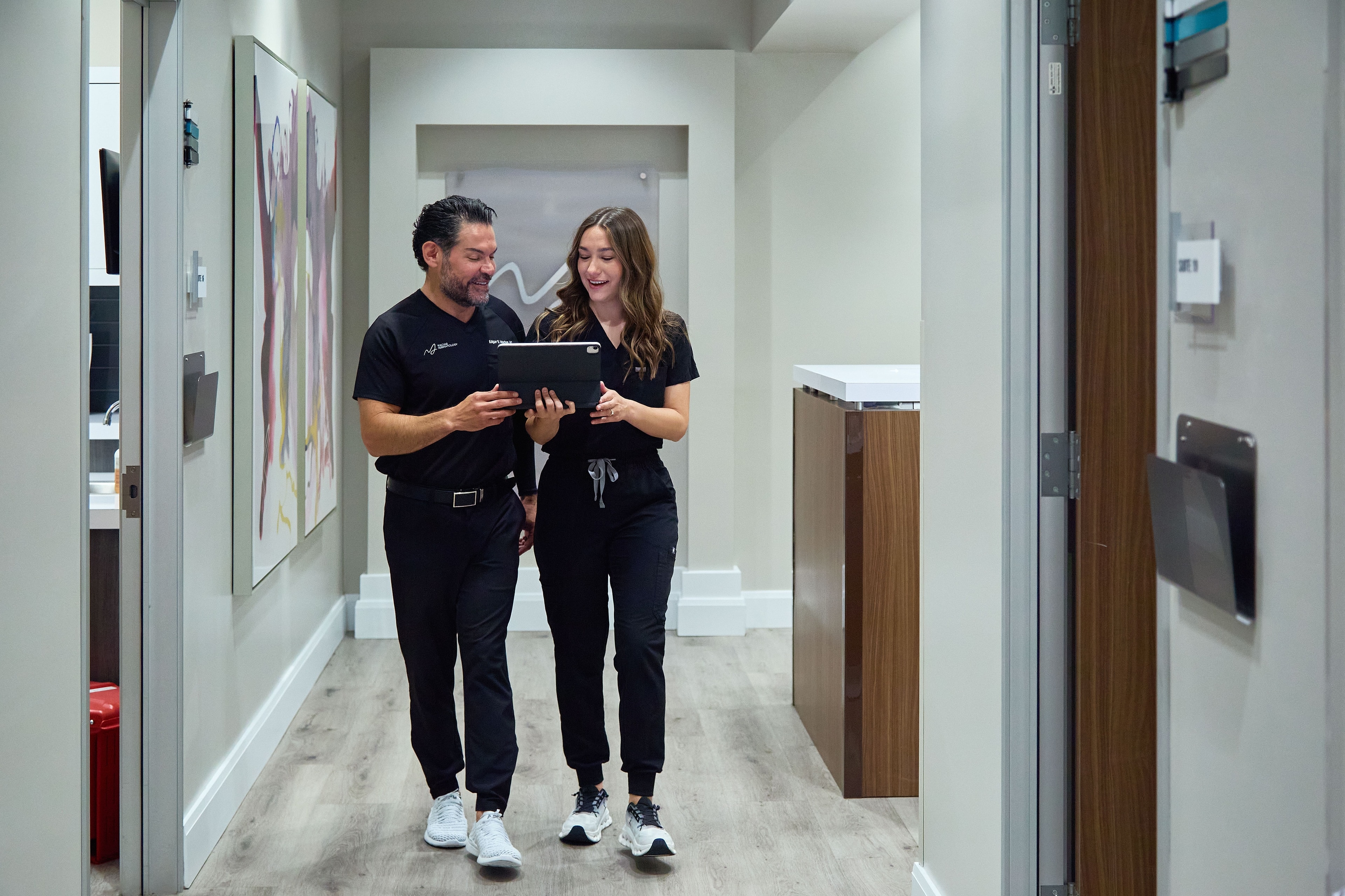 Dr. Macias and a team member reviewing a treatment plan in the clinic hallway