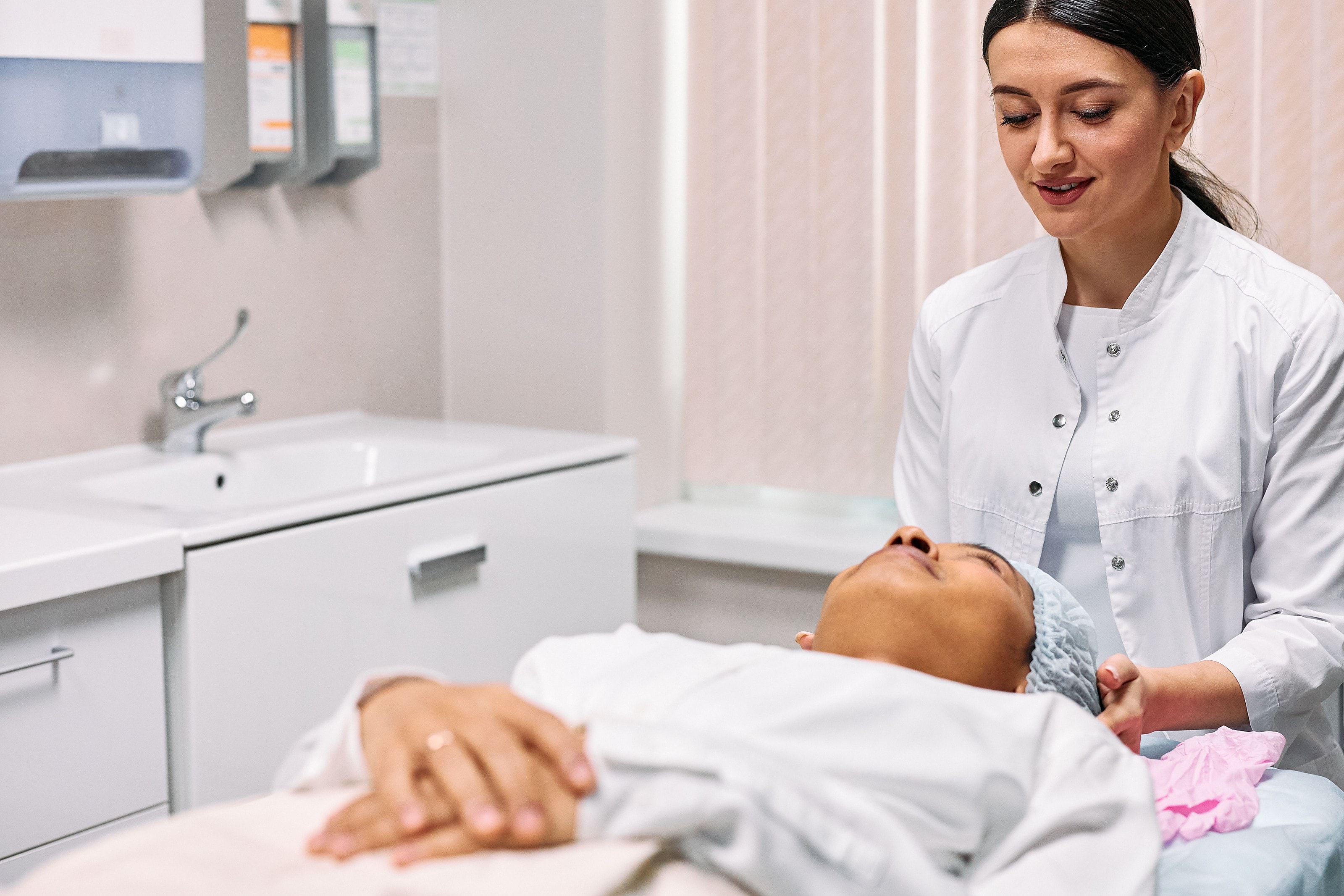 A practitioner attending to a patient resting during a facial treatment