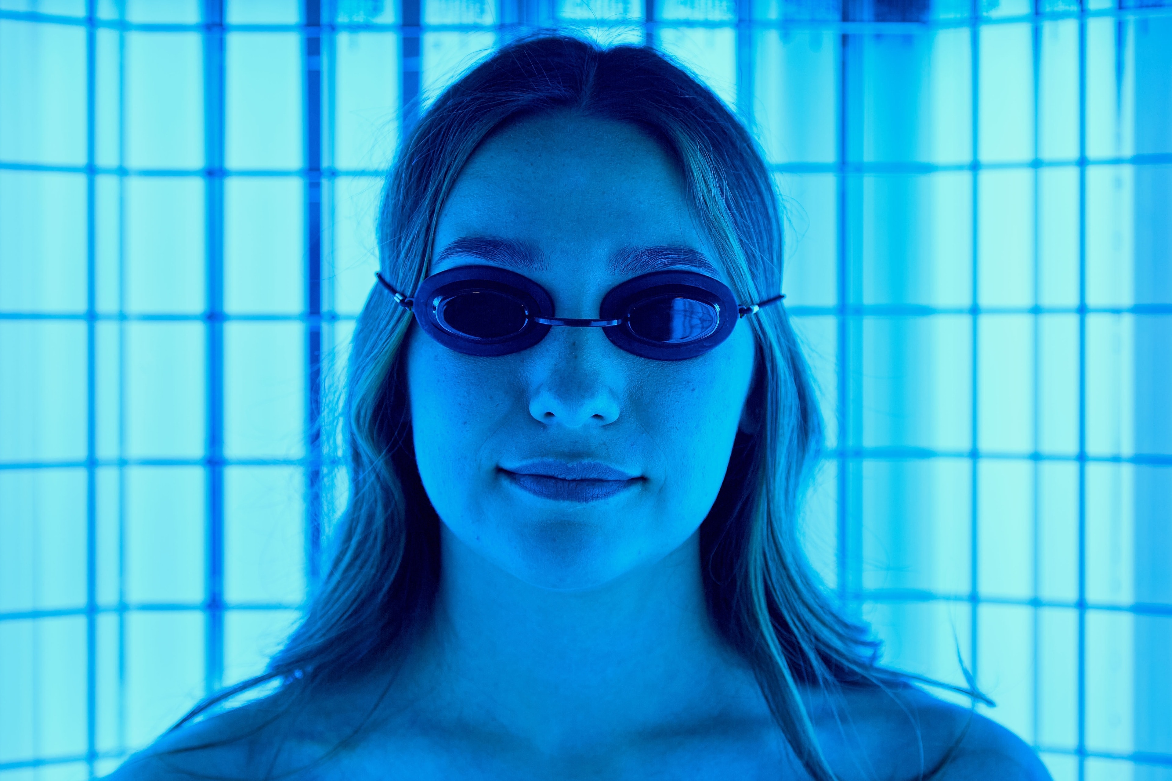 A patient in protective goggles inside the narrow band UVB booth