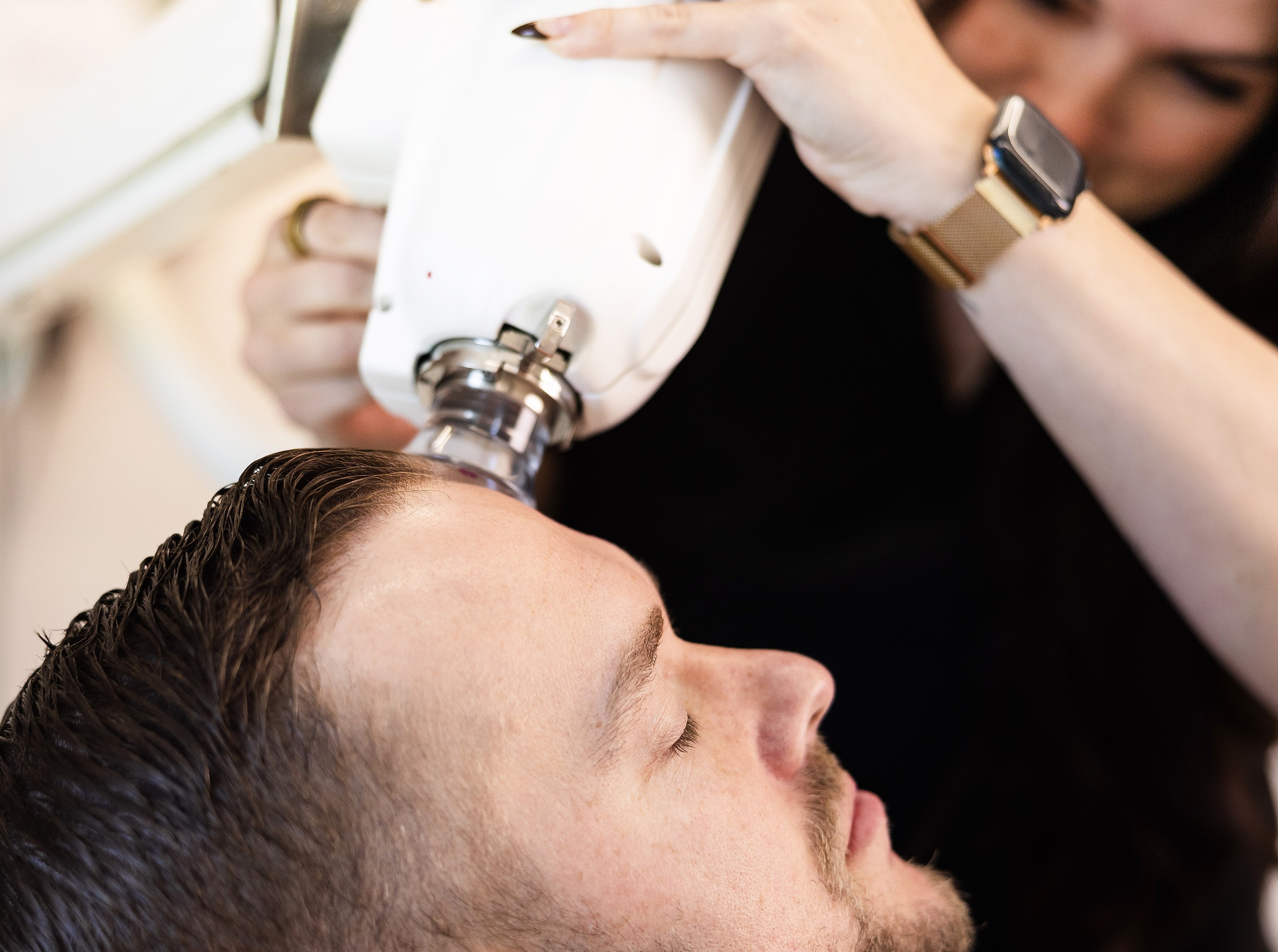 A patient receiving a non-surgical skin cancer treatment, the applicator positioned at his forehead