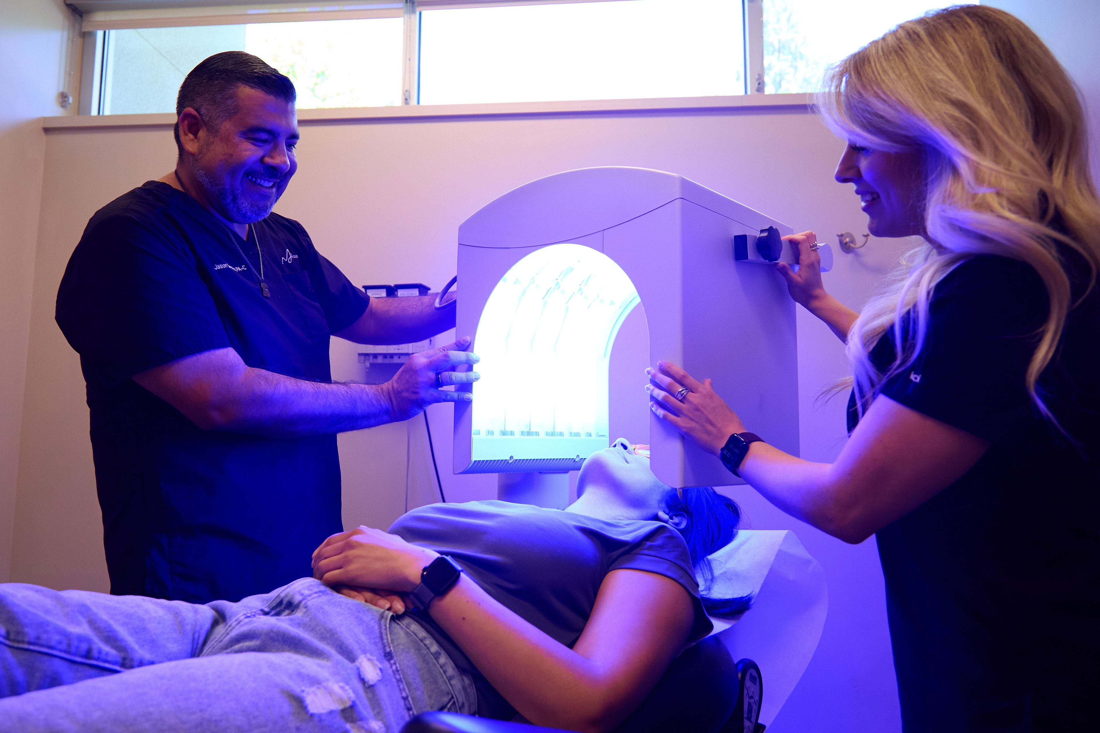 Clinicians positioning the arched light panel over a patient