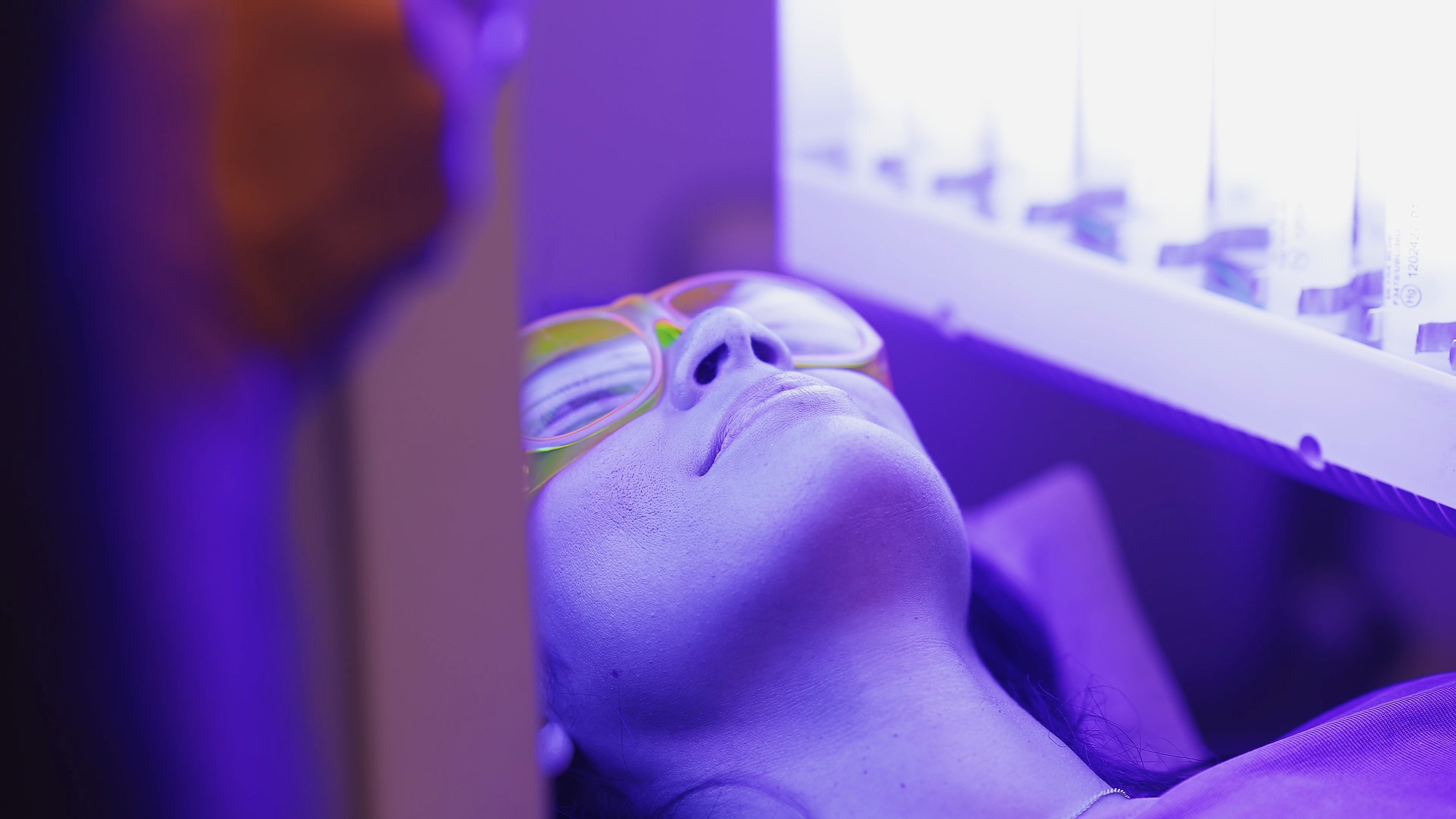 A patient beneath the blue-light therapy unit